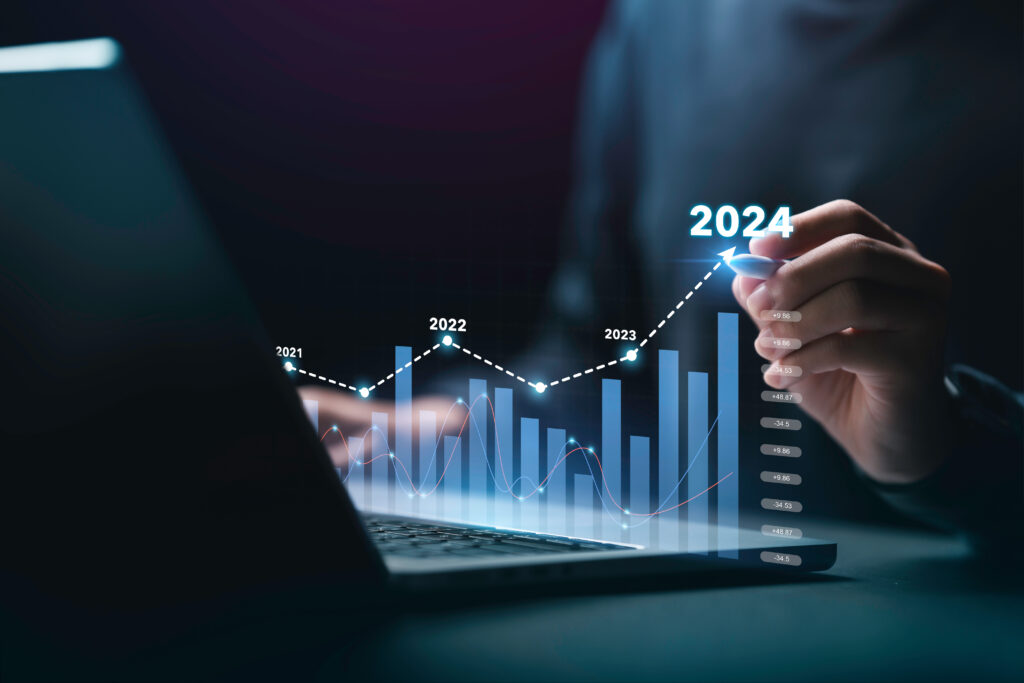Businessman analyzes the graph of trend market growth in 2024 and plans business growth and profit increase in the year 2024. plan finances of the business